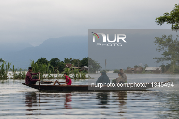 People are moving through flooded water as they are riding on a boat in Companiganj, Sylhet, Bangladesh, on Thursday, June 20, 2024. In Sylh...