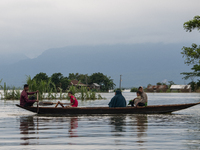 People are moving through flooded water as they are riding on a boat in Companiganj, Sylhet, Bangladesh, on Thursday, June 20, 2024. In Sylh...