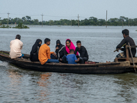 People are moving through flooded water as they are riding on a boat in Companiganj, Sylhet, Bangladesh, on Thursday, June 20, 2024. In Sylh...