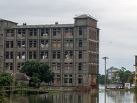 People are sitting on top of a building being used as a shelter for flood-affected people in Companiganj, Sylhet, Bangladesh, on Thursday, J...