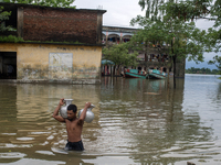 A man is carrying drinking water towards his home in Companiganj, Sylhet, Bangladesh, on June 20, 2024. In Sylhet, lashing rain and rivers s...