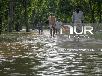 People are wading through a flooded street in Companiganj, Sylhet, Bangladesh, on June 20, 2024. In Sylhet, lashing rain and rivers swollen...