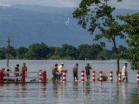 People are wading through a flooded street in Companiganj, Sylhet, Bangladesh, on June 20, 2024. In Sylhet, lashing rain and rivers swollen...