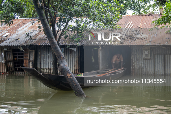 A man is coming out with his boat from his partially submerged house in flood waters in Companiganj, Sylhet, Bangladesh, on Thursday, June 2...