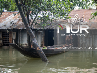 A man is coming out with his boat from his partially submerged house in flood waters in Companiganj, Sylhet, Bangladesh, on Thursday, June 2...