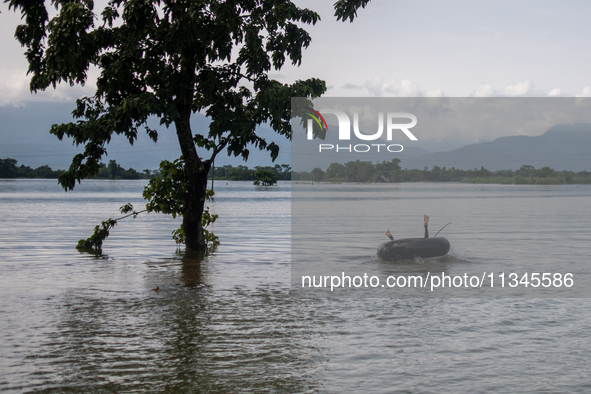 A child is playing with a raft in floodwater in Companiganj, Sylhet, Bangladesh, on Thursday, June 20, 2024. In Sylhet, lashing rain and riv...