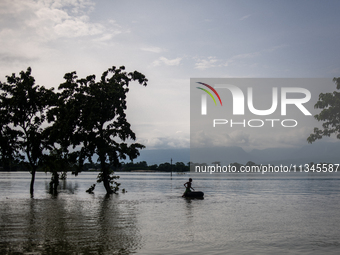 A child is riding a raft in floodwater in Companiganj, Sylhet, Bangladesh, on Thursday, June 20, 2024. In Sylhet, lashing rain and rivers sw...