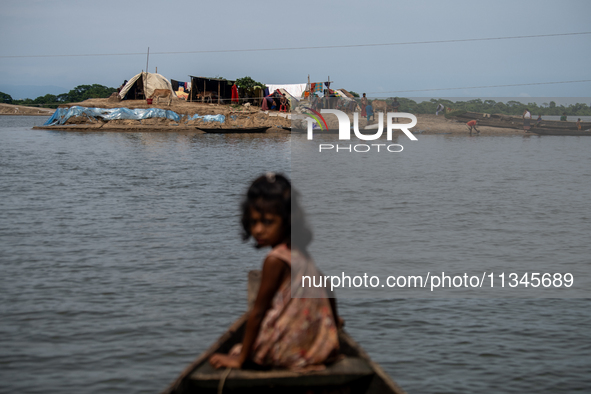 A child is reacting to the camera as she is moving towards temporary shelter in an elevated space during flooding in Companiganj, Sylhet, Ba...