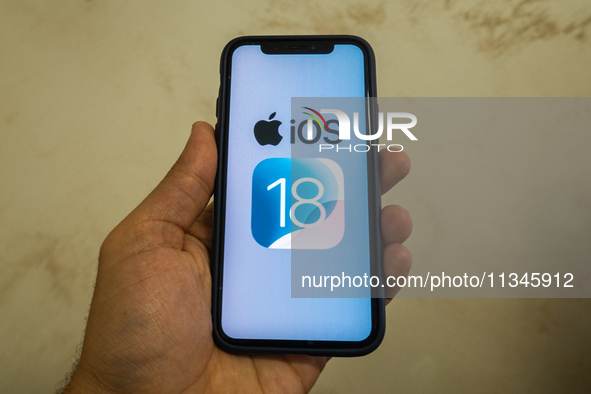 The Apple logo is seen with the iOS 18 operating system logo on a mobile device in this illustration photo taken in L’Aquila, Italy, on June...