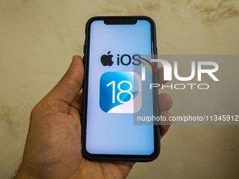 The Apple logo is seen with the iOS 18 operating system logo on a mobile device in this illustration photo taken in L’Aquila, Italy, on June...