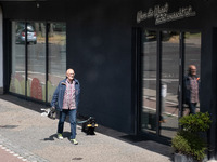 A man is walking with his dog in Berlin, Germany, on June 20, 2024. (