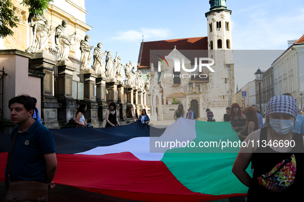 People are participating in a solidarity protest with Palestine in Krakow, Poland, on June 20, 2024, and are marching from the Main Square t...