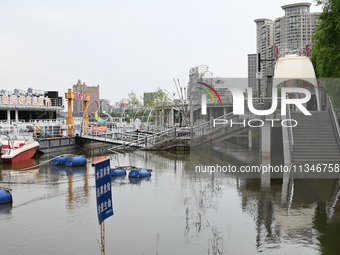 Part of the pedestrian walkway is being submerged by the rising waters of the Sandao pier along the Songhua River in Jilin City, Jilin provi...