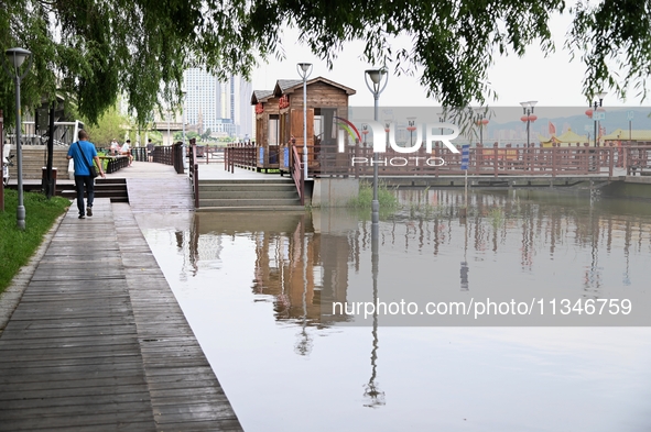 Part of the pedestrian walkway is being submerged by the rising waters of the Sandao pier along the Songhua River in Jilin City, Jilin provi...