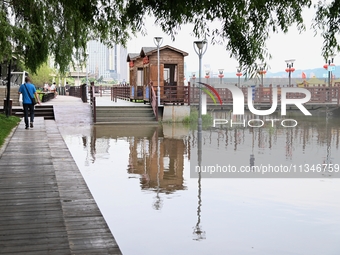 Part of the pedestrian walkway is being submerged by the rising waters of the Sandao pier along the Songhua River in Jilin City, Jilin provi...