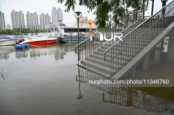 Part of the pedestrian walkway is being submerged by the rising waters of the Sandao pier along the Songhua River in Jilin City, Jilin provi...