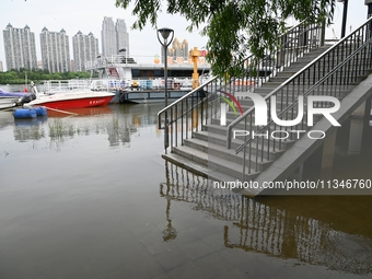 Part of the pedestrian walkway is being submerged by the rising waters of the Sandao pier along the Songhua River in Jilin City, Jilin provi...