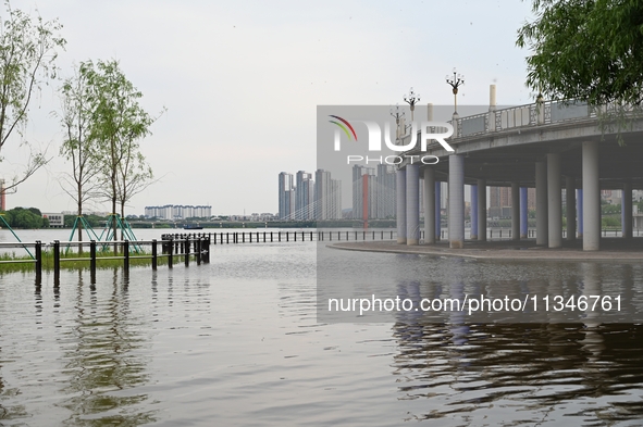 Part of the pedestrian walkway is being submerged by the rising waters of the Sandao pier along the Songhua River in Jilin City, Jilin provi...