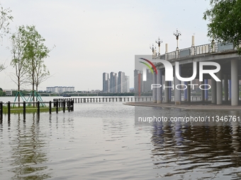 Part of the pedestrian walkway is being submerged by the rising waters of the Sandao pier along the Songhua River in Jilin City, Jilin provi...