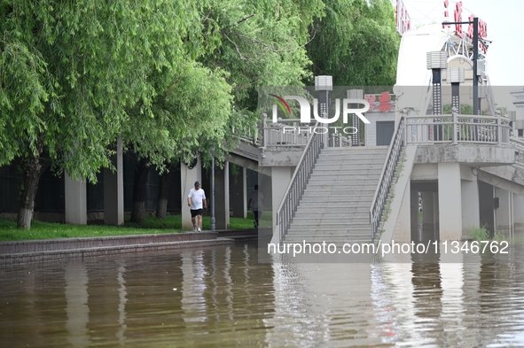 Part of the pedestrian walkway is being submerged by the rising waters of the Sandao pier along the Songhua River in Jilin City, Jilin provi...