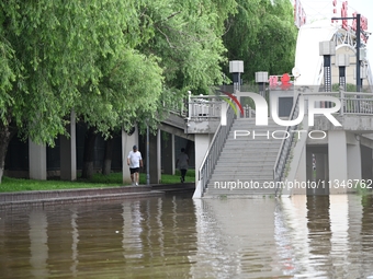 Part of the pedestrian walkway is being submerged by the rising waters of the Sandao pier along the Songhua River in Jilin City, Jilin provi...