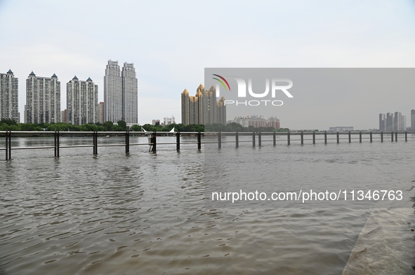 Part of the pedestrian walkway is being submerged by the rising waters of the Sandao pier along the Songhua River in Jilin City, Jilin provi...