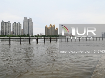 Part of the pedestrian walkway is being submerged by the rising waters of the Sandao pier along the Songhua River in Jilin City, Jilin provi...