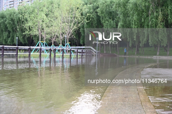 Part of the pedestrian walkway is being submerged by the rising waters of the Sandao pier along the Songhua River in Jilin City, Jilin provi...