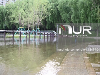 Part of the pedestrian walkway is being submerged by the rising waters of the Sandao pier along the Songhua River in Jilin City, Jilin provi...