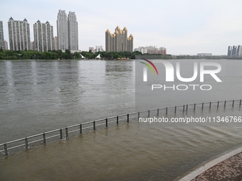 Part of the pedestrian walkway is being submerged by the rising waters of the Sandao pier along the Songhua River in Jilin City, Jilin provi...