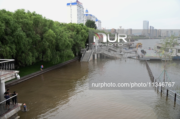 Part of the pedestrian walkway is being submerged by the rising waters of the Sandao pier along the Songhua River in Jilin City, Jilin provi...