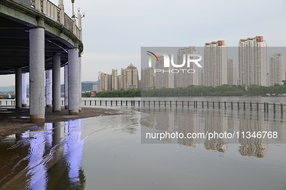 Part of the pedestrian walkway is being submerged by the rising waters of the Sandao pier along the Songhua River in Jilin City, Jilin provi...