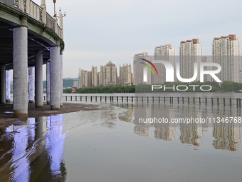 Part of the pedestrian walkway is being submerged by the rising waters of the Sandao pier along the Songhua River in Jilin City, Jilin provi...