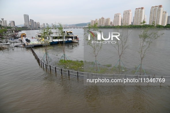 Part of the pedestrian walkway is being submerged by the rising waters of the Sandao pier along the Songhua River in Jilin City, Jilin provi...