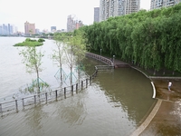 Part of the pedestrian walkway is being submerged by the rising waters of the Sandao pier along the Songhua River in Jilin City, Jilin provi...