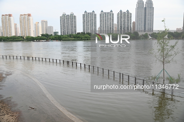 Part of the pedestrian walkway is being submerged by the rising waters of the Sandao pier along the Songhua River in Jilin City, Jilin provi...