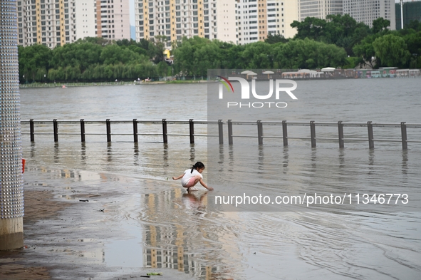 Part of the pedestrian walkway is being submerged by the rising waters of the Sandao pier along the Songhua River in Jilin City, Jilin provi...