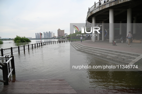 Part of the pedestrian walkway is being submerged by the rising waters of the Sandao pier along the Songhua River in Jilin City, Jilin provi...