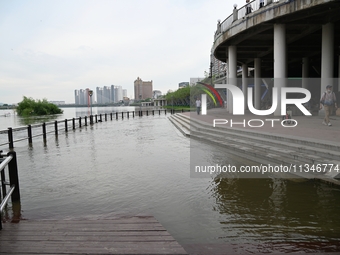 Part of the pedestrian walkway is being submerged by the rising waters of the Sandao pier along the Songhua River in Jilin City, Jilin provi...