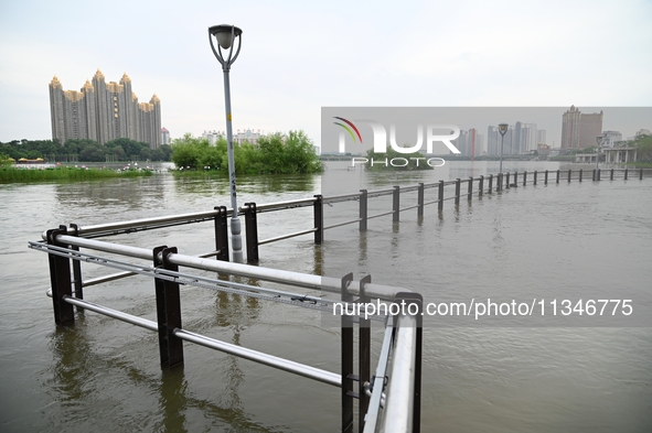 Part of the pedestrian walkway is being submerged by the rising waters of the Sandao pier along the Songhua River in Jilin City, Jilin provi...