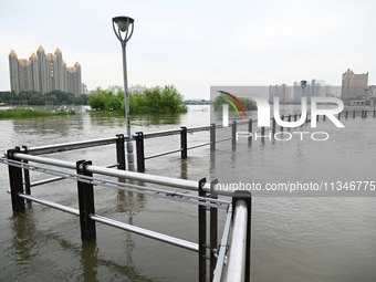 Part of the pedestrian walkway is being submerged by the rising waters of the Sandao pier along the Songhua River in Jilin City, Jilin provi...