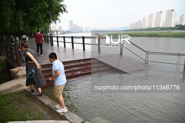 Part of the pedestrian walkway is being submerged by the rising waters of the Sandao pier along the Songhua River in Jilin City, Jilin provi...