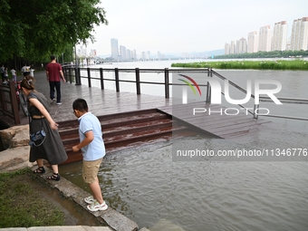 Part of the pedestrian walkway is being submerged by the rising waters of the Sandao pier along the Songhua River in Jilin City, Jilin provi...