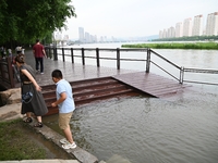 Part of the pedestrian walkway is being submerged by the rising waters of the Sandao pier along the Songhua River in Jilin City, Jilin provi...