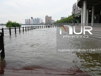 Part of the pedestrian walkway is being submerged by the rising waters of the Sandao pier along the Songhua River in Jilin City, Jilin provi...