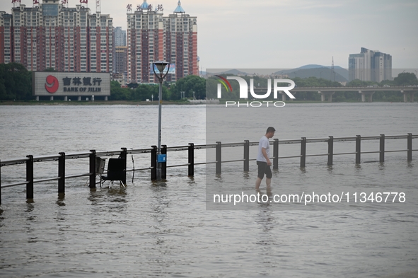 Part of the pedestrian walkway is being submerged by the rising waters of the Sandao pier along the Songhua River in Jilin City, Jilin provi...