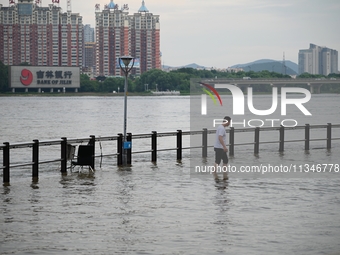 Part of the pedestrian walkway is being submerged by the rising waters of the Sandao pier along the Songhua River in Jilin City, Jilin provi...