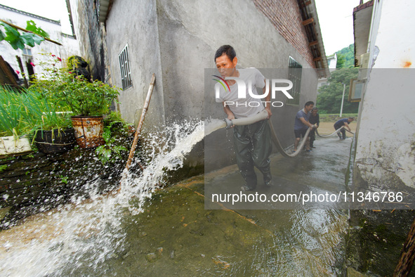 Villagers are cleaning up silt at Changjing Village in Qiukou, Wuyuan county, Shangrao city, East China's Jiangxi province, on June 20, 2024...