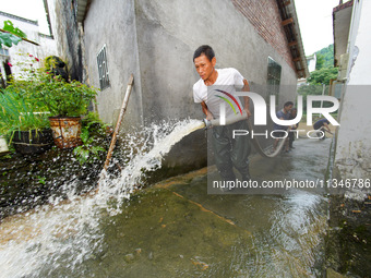 Villagers are cleaning up silt at Changjing Village in Qiukou, Wuyuan county, Shangrao city, East China's Jiangxi province, on June 20, 2024...