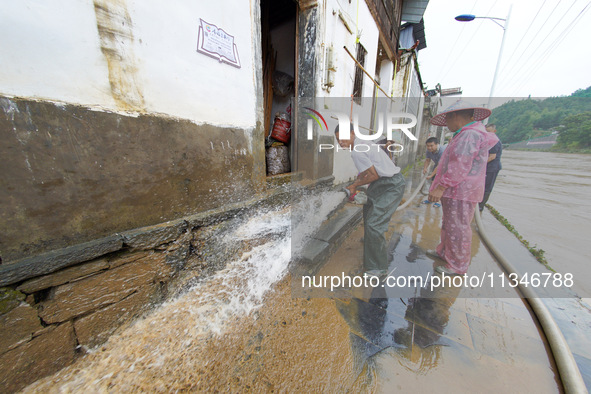 Villagers are cleaning up silt at Changjing Village in Qiukou, Wuyuan county, Shangrao city, East China's Jiangxi province, on June 20, 2024...